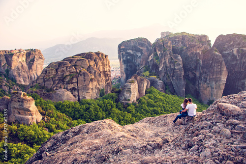 Loving couple makes a photo on a mobile phone in the mountains at sunset.