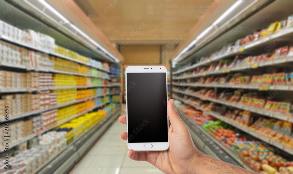 Hand holding a smartphone with black screen on blur super market background, copy space Hand holding a smartphone with black screen on blur super market background, copy space