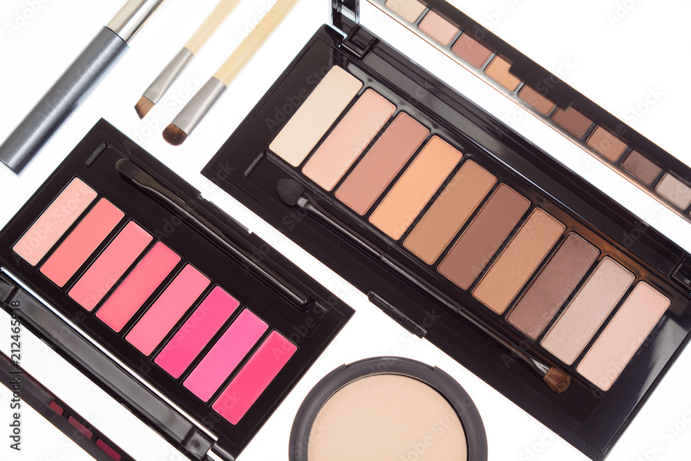 Collection of two cosmetics palettes for eye and lip makeup isolated. Vivid colorful tints, hot colors for face make-up. Lipsticks and eyeshadows kit. Mascara, brushes and powder. Top view.