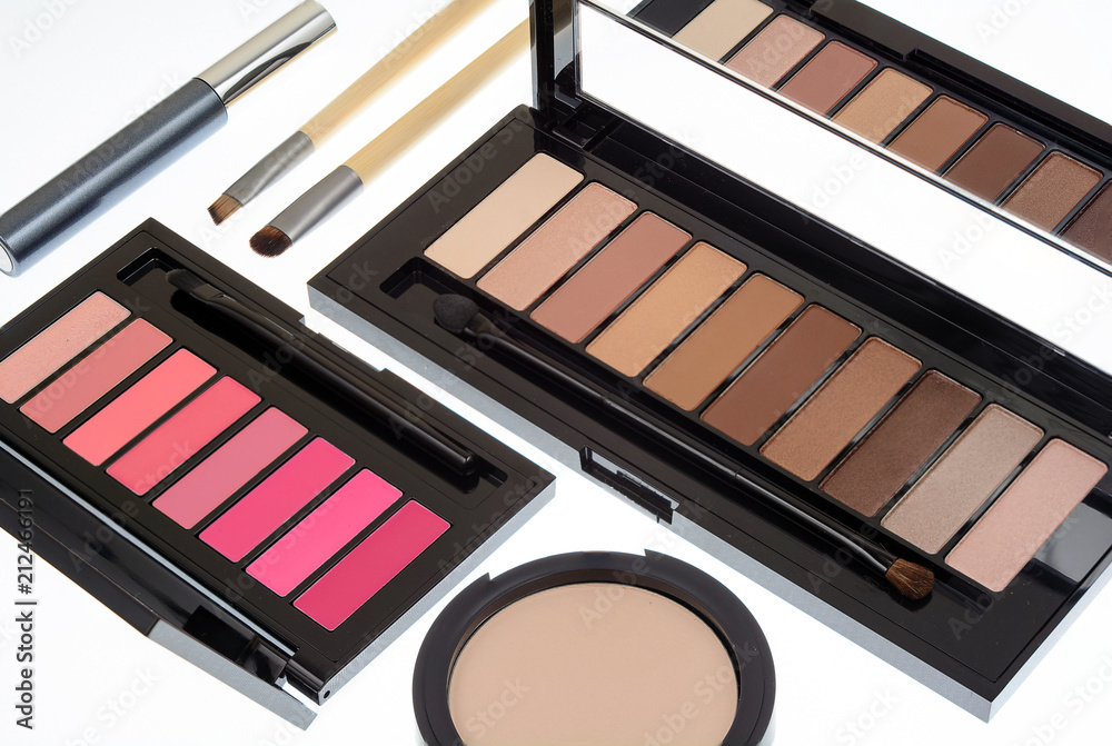 Collection of two cosmetics palettes for eye and lip makeup isolated. Vivid colorful tints, hot colors for face make-up. Lipsticks and eyeshadows kit. Mascara, brushes and powder. Side view.