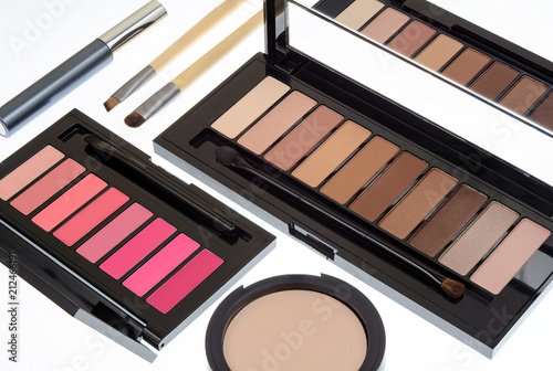 Collection of two cosmetics palettes for eye and lip makeup isolated. Vivid colorful tints, hot colors for face make-up. Lipsticks and eyeshadows kit. Mascara, brushes and powder. Side view.