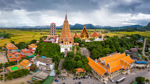 Aerial view of Wat Tham Sua Temple with rice fields in Kanchanaburi Province, Thailand.