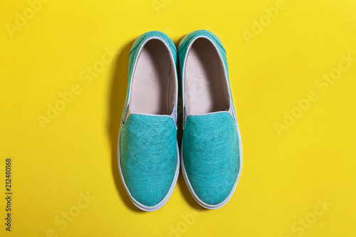 stylish women blue slip on shoes standing on the yellow surface. view from the top. spring summer hipster trend. free space for advertising text