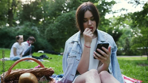 Young beautiful girl sitting by the fire at a picnic in the summer photo