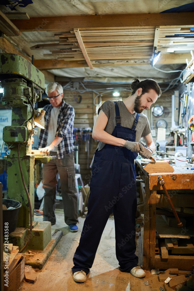 Two woodworking masters processing wooden workpieces with handtools and by machine Two woodworking masters processing wooden workpieces with handtools and by machine