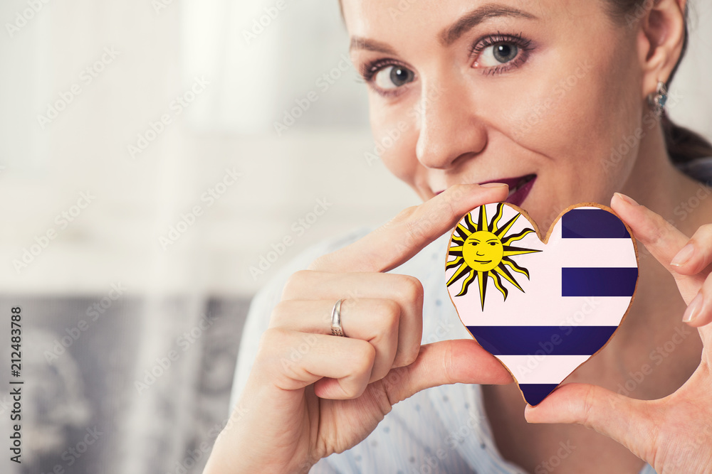 Young woman with gingerbread heart cookies with flag of Uruguay Young woman with gingerbread heart cookies with flag of Uruguay