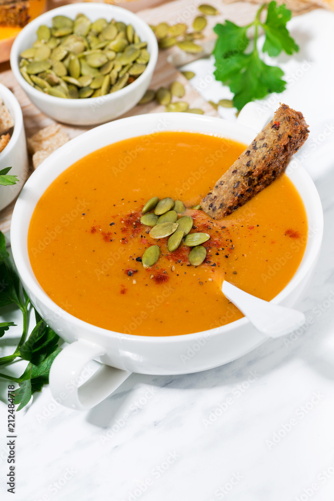 fresh soup of pumpkin and lentils on white background, closeup vertical fresh soup of pumpkin and lentils on white background, closeup vertical