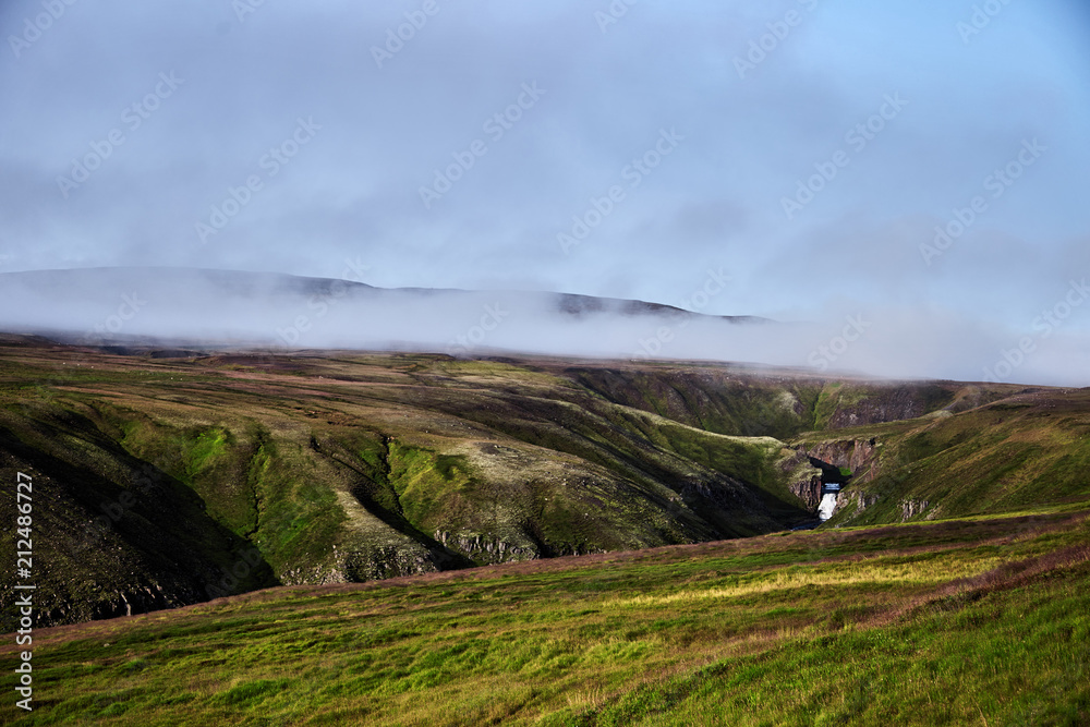 Iceland landscape. Small waterfall in the mountains of Iceland. Iceland landscape. Small waterfall in the mountains of Iceland.
