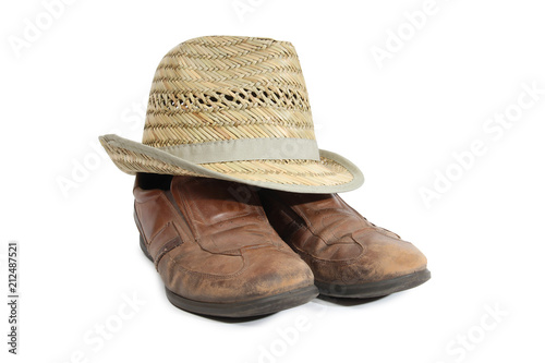 Old shoes and a straw hat on a white background photo