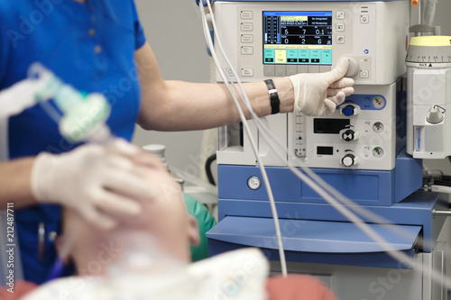 An anesthesiologist monitors the condition of a patient under general anesthesia
