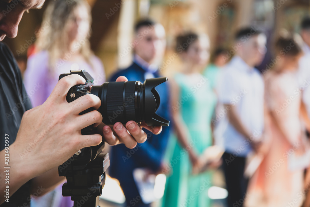 Naklejka premium Professional videographer provides services of filming ceremonial event, matte toning effect 