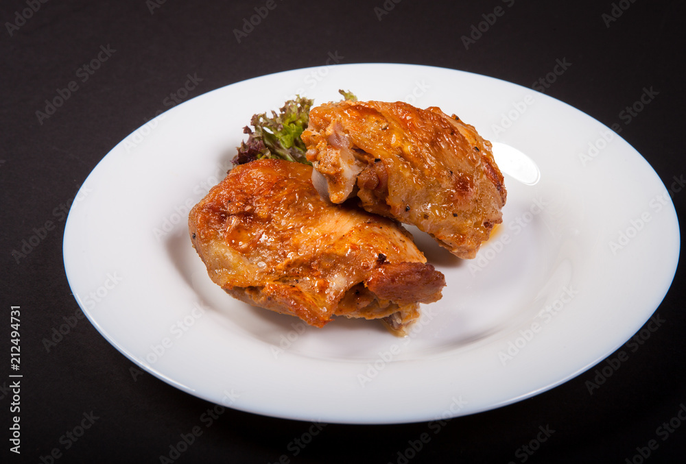 Fried chicken fillet on a plate isolated on a black background Fried chicken fillet on a plate isolated on a black background