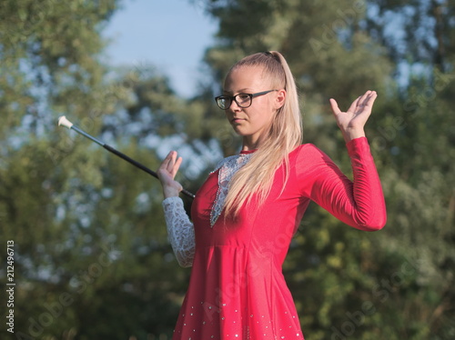 Teen Majorette Girl Twirling Baton Outdoors photo