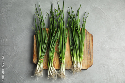 Fresh green onion on wooden board, top view