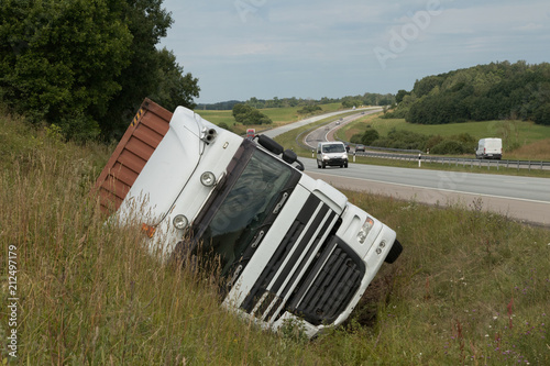 The large truck lies in a side ditch after the road accident
