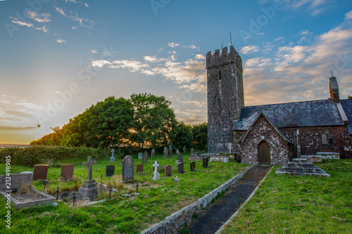 Evening light falls upon St Petrox Church, Pembrokeshire photo