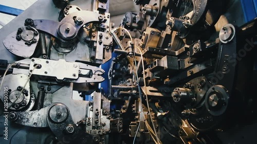 Automatic industrial conveyor machine for the manufacture of parts from steel wire. A lot of gears in one big gear.