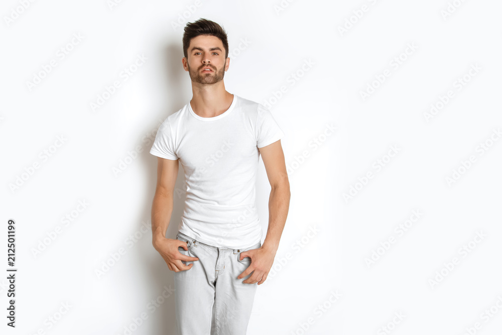 Strong face male model in casual style in white t sirt and jeans on white background Strong face male model in casual style in white t sirt and jeans on white background