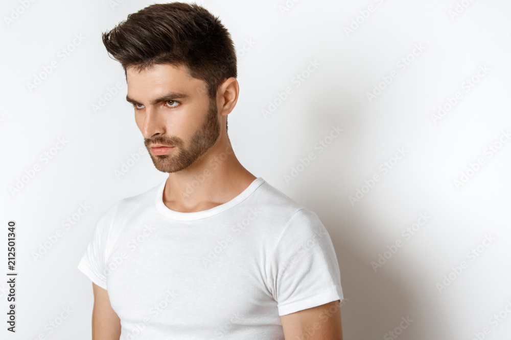 Strong face male model in casual style in white t sirt and jeans on white background Strong face male model in casual style in white t sirt and jeans on white background