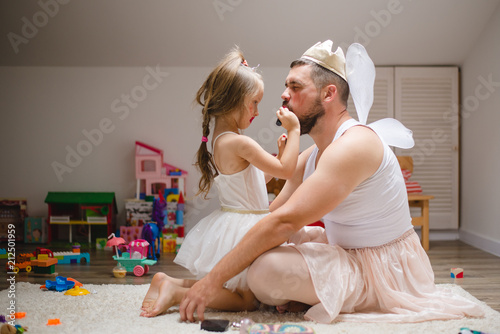 Little daughter and father have fun, dressing in princess costume, daddy makeup