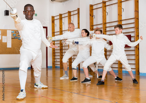 African American wearing fencing uniform practicing with foil