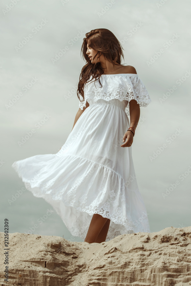 Female beauty girl model brunette in a dress on the mountain and dessert sand font Female beauty girl model brunette in a dress on the mountain and dessert sand font