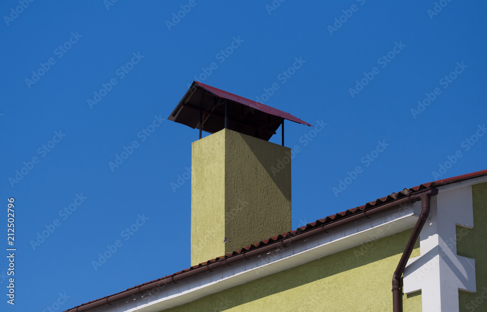 Chimney on the roof. Clear blue sky background