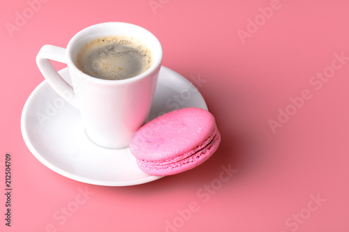 One pink macaroon with cup of coffee