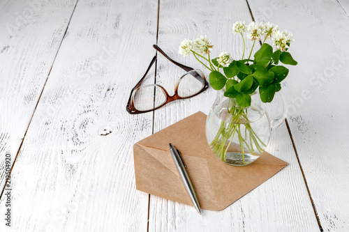 Summer mood with white clover on wooden table photo