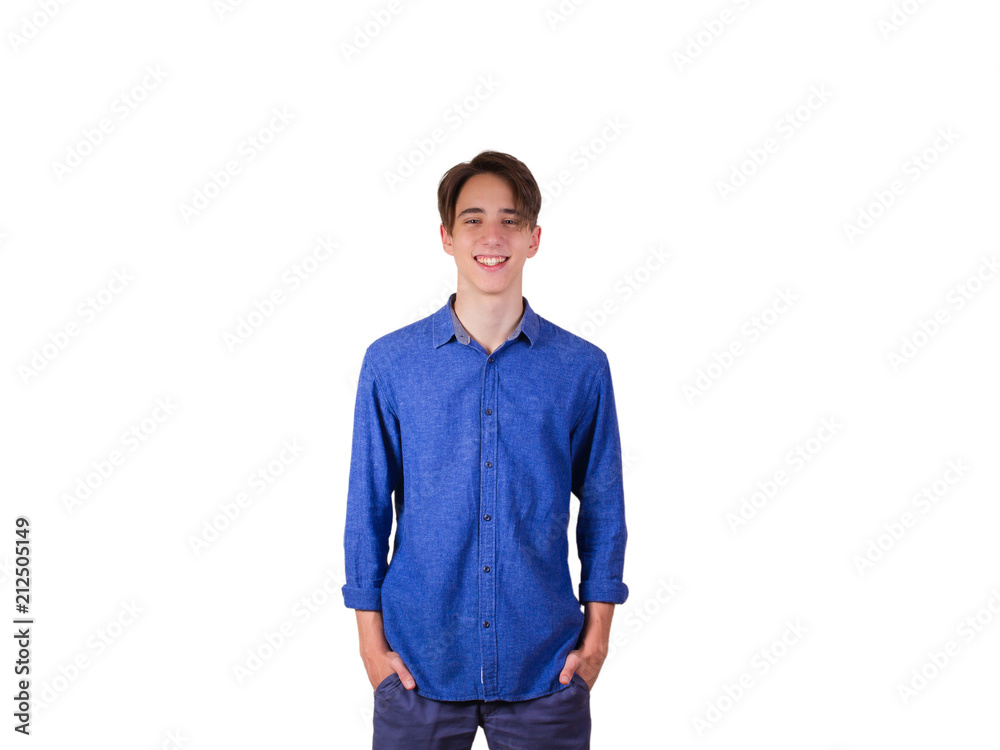 Young man looking at camera, smiling. Portrait of teen boy in blue jeans shirt, hands in pockets, isolated on white background Young man looking at camera, smiling. Portrait of teen boy in blue jeans shirt, hands in pockets, isolated on white background