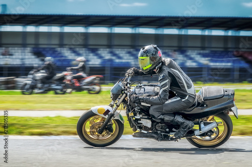 Motorcycle racer on sportbike leaning into a fast corner on track photo