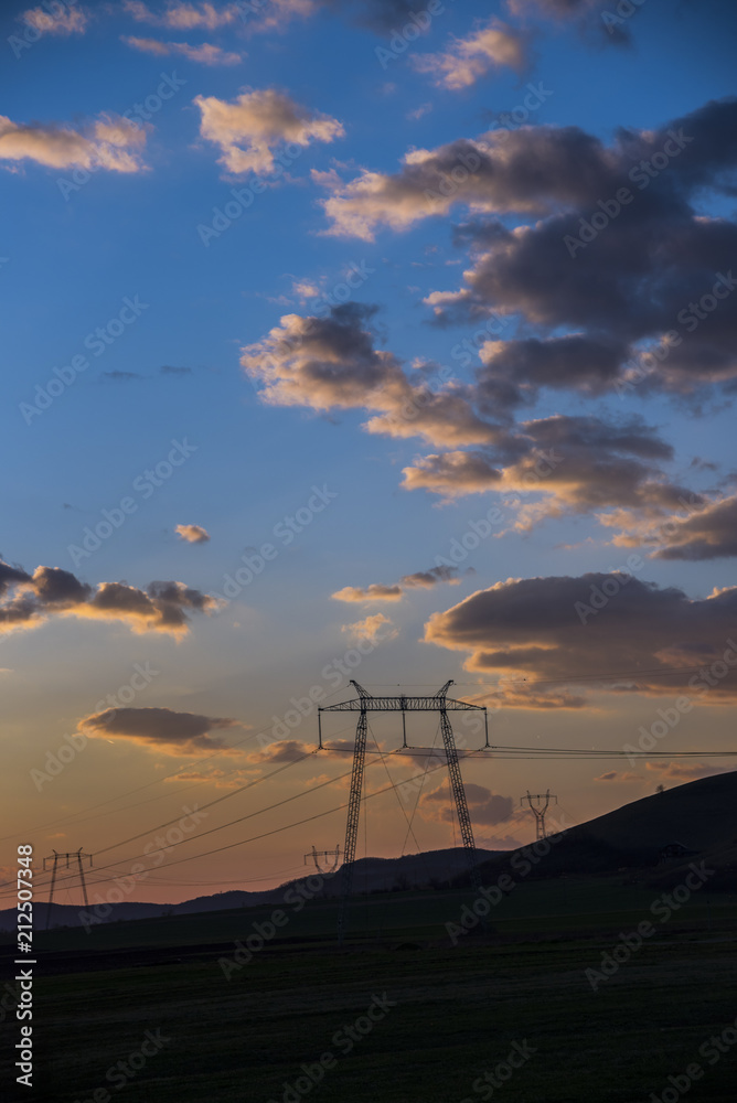 Obraz premium pylon power turbines at sunset