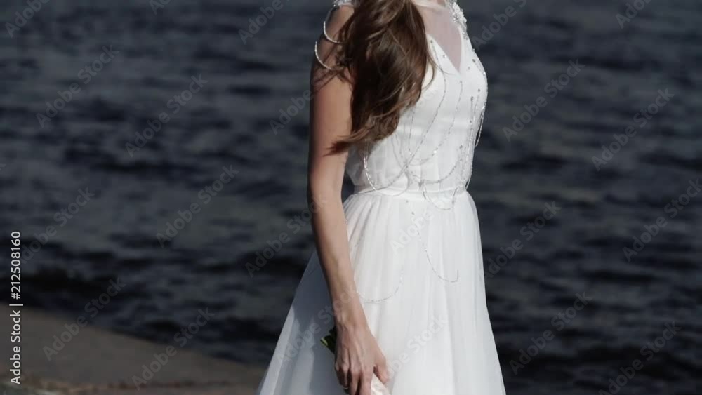 Bride walking on embankment in a city Bride walking on embankment in a city