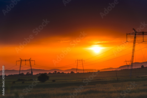 Electric pylons and clouds at the sunset