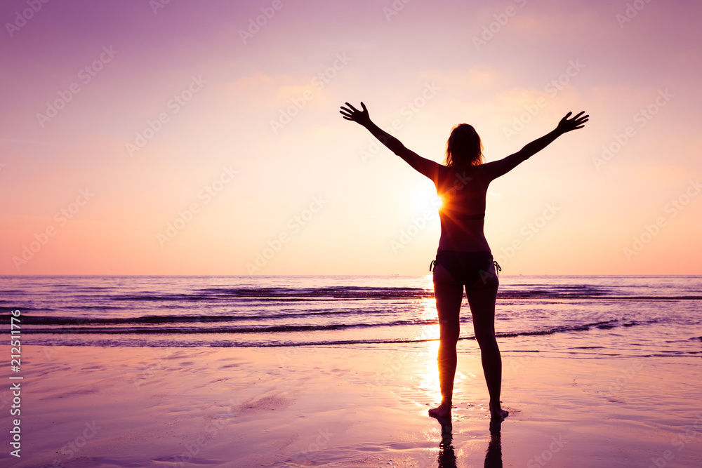 Happy joyful woman spreading hands on the beach at sunset, cheerful emotion and mindfulness, balance, mindful thinking