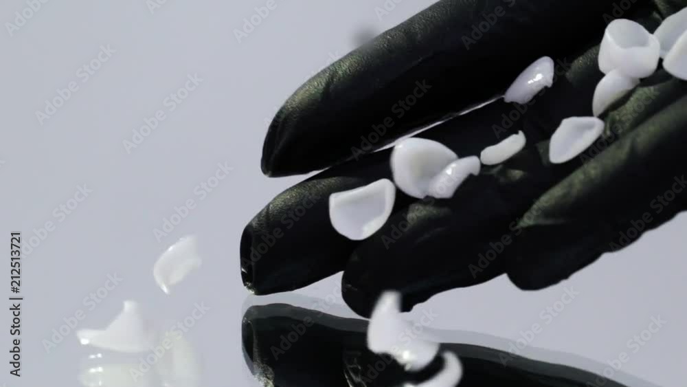 Dental veneers on isolated background in doctor hands