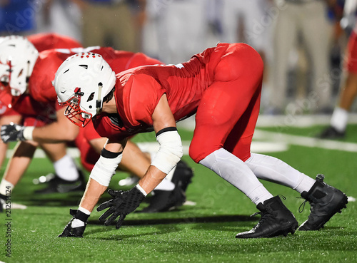 Football lineman blocking and rushing during a football game