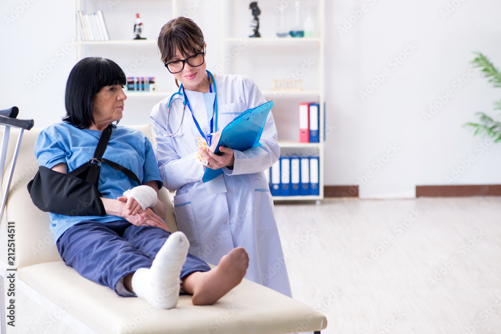 Fototapeta premium Doctor examining old mature woman after incident