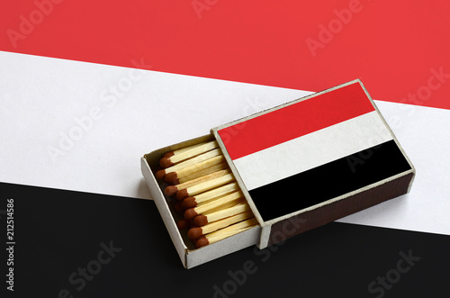 Yemen flag  is shown in an open matchbox, which is filled with matches and lies on a large flag photo