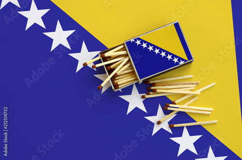 Bosnia and Herzegovina flag  is shown on an open matchbox, from which several matches fall and lies on a large flag photo