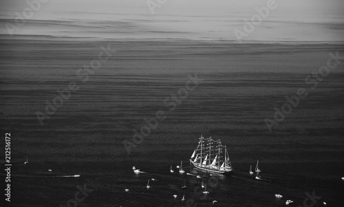 A large sailboat, bark goes into the sea surrounded by many yachts.
The last windjammer bark Kruzenstern. photo