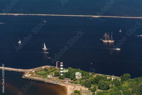 The mouth of the river Daugava. Bolderaja lighthouse and pier and breakwater. Sailboats and yachts go to sea.  photo