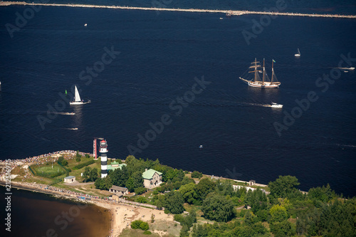 The mouth of the river Daugava. Bolderaja lighthouse and pier and breakwater. Sailboats and yachts go to sea.  photo