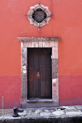 Front of an old mexican house, Colonial style door and decorative window, San Miguel de Allende Mexico