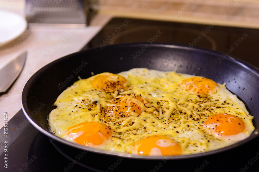 Fried eggs in the frying pan with cheese at home. Fried eggs in the frying pan with cheese at home.