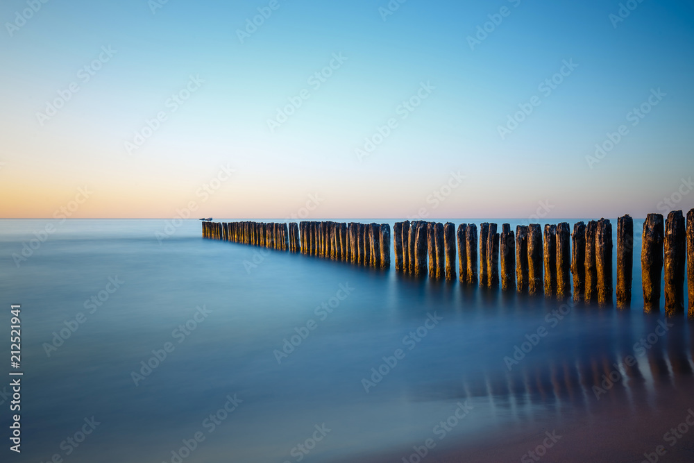 Sunset on the beach with breakwater, long time exposure