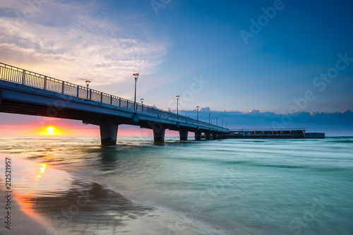 quiet beach with pier at sunset, long time exposure