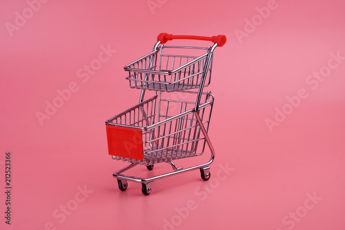 Shopping trolley on pink background