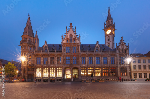 Former building of post office, Oude Postkantoor, with clock tower on Korenmarkt at night, Ghent, Belgium