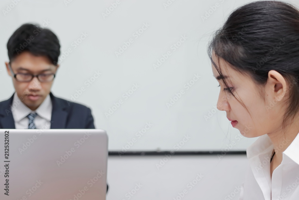 Close up face of unhappy Asian business woman having conflict with her colleague in office. Close up face of unhappy Asian business woman having conflict with her colleague in office.